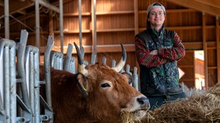 Mark Junglas neben Rind im Stall