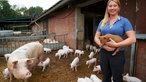 Theresa Leiders hält ein Ferkel auf dem Arm. 