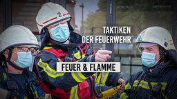 Drei Feuerwehrmänner bei der Taktikbesprechung 