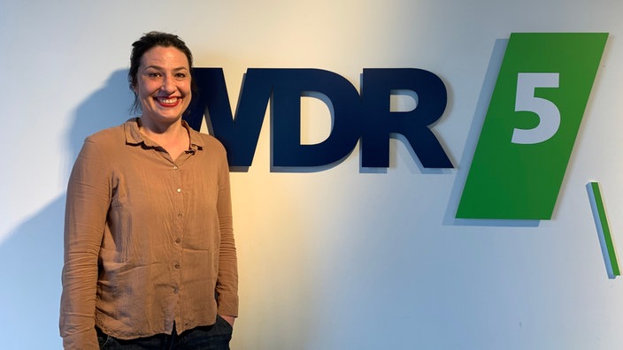 Eva Eiselt vor dem WDR 5 Logo