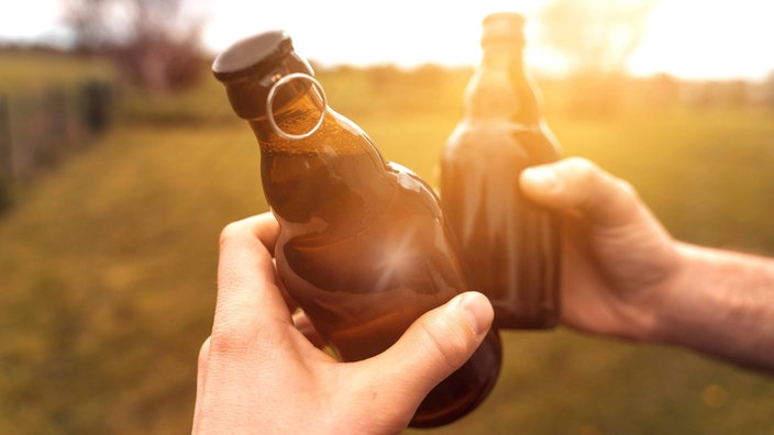 Zwei Freunde stoßen mit einem Bier an