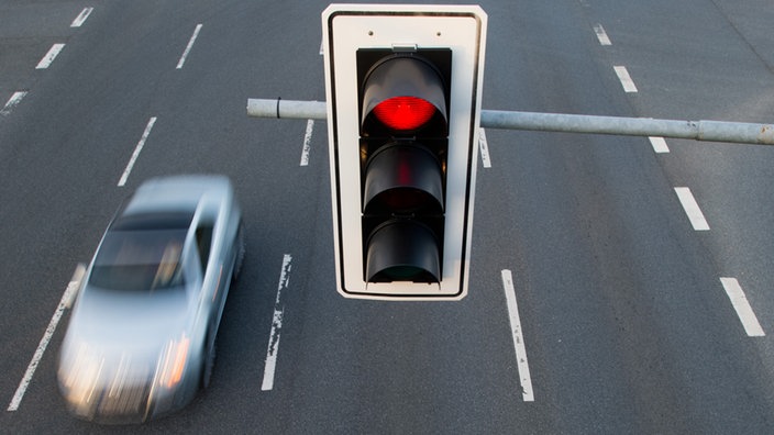 Ein Auto fährt unter einer roten Ampel hindurch