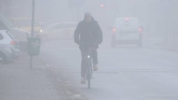 Fahrradfahrer fährt durch den Nebel