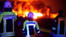 Feuerwehrkräfte bei einem Brand von hinten fotografiert