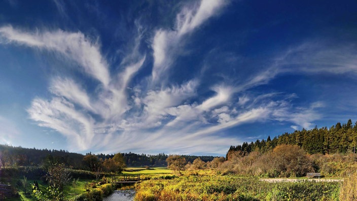 Eine Landschaft mit Schleierwolken und Sonnenschein