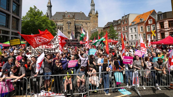 3.000 Menschen sind in Aachen mit Fahnen und Plakaten bei der DGB-Demo.