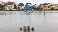 Blick auf einen überfluteten Parkscheinautomaten am Parkplatz ·Schlagde·, einem alten Umschlageplatz und Uferhafen der Weser