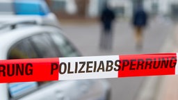 Polizeiabsperrung: Rotes Flatterband mit Aufschrift