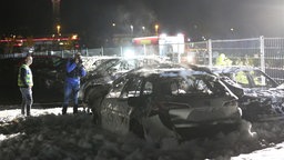 Ein Polizist sichtet die gelöschten Fahrzeuge.