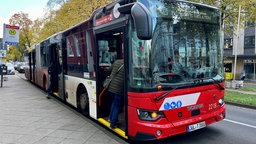 Menschen steigen in einen Bus der AVV ein