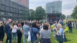 Menschen auf der Wiese vor dem Düsseldorfer Landtag demonstrieren gegen den Kita-Kollaps