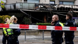 Polizisten sichern den Bereich nach einer Explosion in Köln Pesch im September.  Im Hintergrund ist das beschädigte Haus zu sehen.