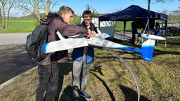 Zwei Studenten öffnen eine Transportdrohne