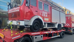 Ein Feuerwehrauto ist auf einem Anhänger befestigt