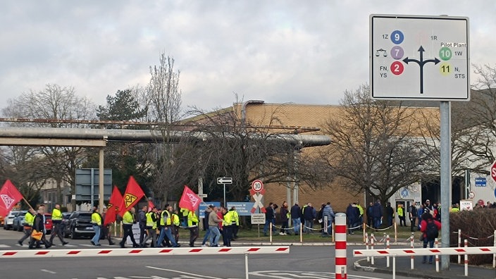 Menschen in Warnwesten auf dem Ford-Gelände in Köln