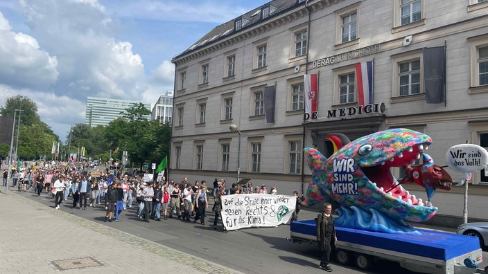 Jacques Tilly's Wagen zeigt einen großen Fisch, der einen kleineren mit der Sprechblase "Wir sind das Volk!" verspeist