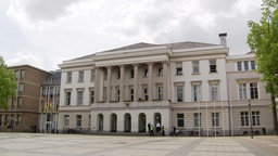 Das Krefelder Rathaus, darüber ein bewölkter Himmel