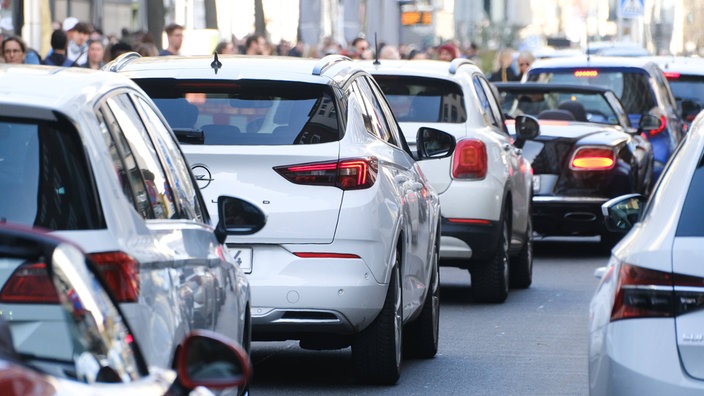 Auf dem Foto sind viele Autos, die dicht gedrängt auf einer mehrspuringen Straße durch die Düsseldorfer Innenstadt fahren.