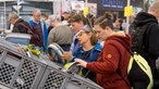 Viele Personen begutachten Campinggeschirr an einem Messestand.