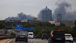 Eine Rauchwolke steht über der Skyline von Duisburg, im Vordergrund die Autobahn