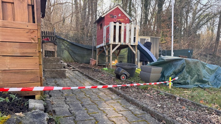 Ein Bereich des Kleingartens, man sieht einen Spielplatz und rotes Flatterband.