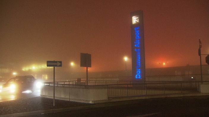 Ein Schild mit der Aufschrift "Dortmund Airport" bei starkem Nebel