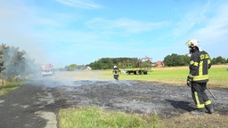 Zwei Personen der Feuerwehr bei Löscharbeiten 