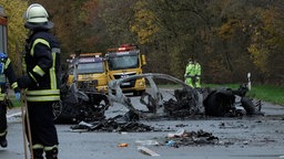 Rettungskräfte stehen neben den Trümmern von Fahrzeugen nach einem Unfall, bei dem sechs Menschen ums Leben gekommen sind. 