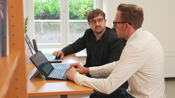 Andreas Stahl, der Leiter der neuen Anlaufstelle für jüdische Studierende an der Uni Münster, sitzt mit einem Mann in einem Büro