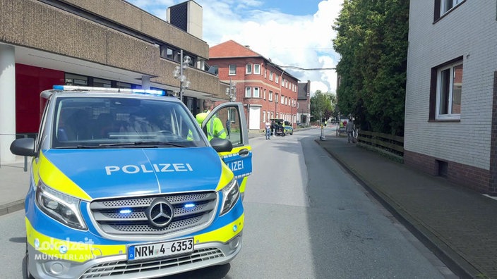 Zwei Polizeiautos auf einer abgesperrten Straße