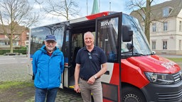 Zwei Männer stehen vor einem kleinen Bus der RVM.