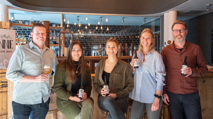 Thorsten Sanderund Studentinnen der Oecotrophologie der Uni Münster und Florian Böckermann, Geschäftsführer der Finne Brauerei, präsentieren das Friedensbier.