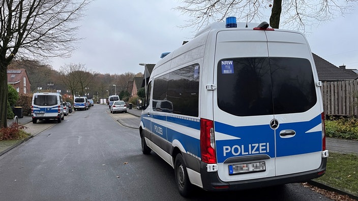 Einsatzwagen der Polizei in einem Wohngebiet.