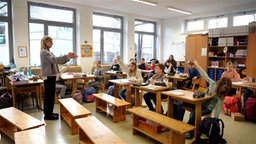 Lehrerin belehrt Kinder im Klassenzimmer