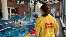 Kinder und Schwimmleherinnen beim Schwimmkurs für Anfänger