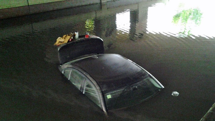 das Auto steht im Wasser unter der Brücke