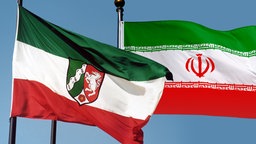 Flagge mit Landeswappen Nordrhein-Westfalen, Nationalfahne Iran (Symbolbild: Wirtschaft)