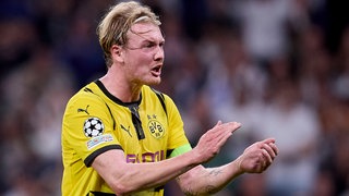 Spielszene: BVB-Offensivspieler Julian Brandt gibt mit rotem Gesicht Anweisungen 