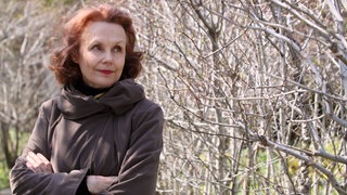 Portraitfoto von der Komponistin Kaija Saariaho in der Natur