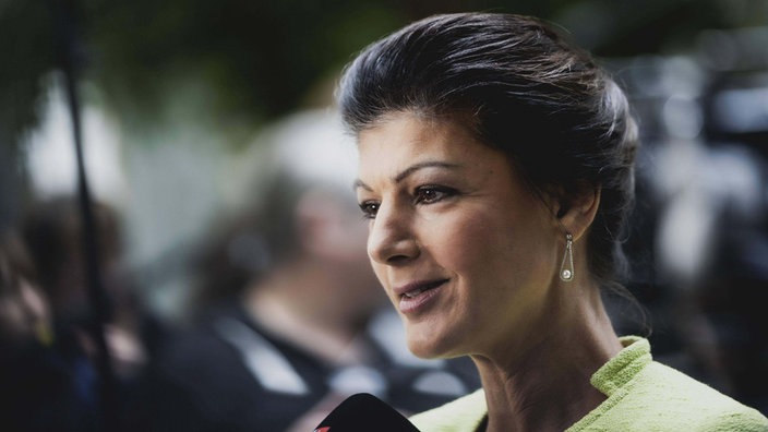 Sahra Wagenknecht lächelt und spricht in ein Mikrofon.