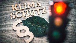 Schriftzug Klimaschutz, Paragrafenzeichen und rote Ampel.