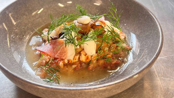 Ein Teller Lachs-Tataki mit Kürbis-Salat und Speck-Vinaigrette von Sternekoch Maximilian Lorenz 