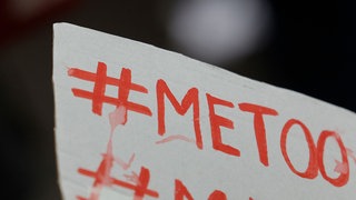 Ein Schild auf dem in roter Schrift MeToo geschrieben steht.