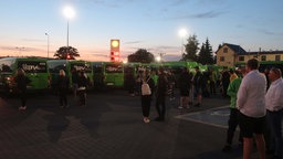 Reisende stehen auf dem Busparkplatz Port Katy in Polen. 