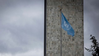 Ein Blick auf den Hauptsitz der Vereinten Nationen, im Hintergrund ein grauer Himmel. 