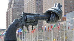 Skulptur - Non Violence - von Carl Fredrik Reuterswärd zeigt eine Pistole mit Knoten im Lauf vor dem UNO-Hauptquartier in Manhattan in New York City