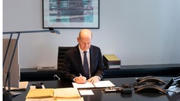 Olaf Scholz unterzeichnet in seinem Büro den Antrag auf die Vertrauensfrage, 11.12.2024.