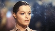 Farbige Porträt-Aufnahme zeigt Romy Schneider, sie blickt ernst und traurig in die Ferne, ihr langes Haar ist streng zurückgekämmt, in der Mitte gescheitelt. 