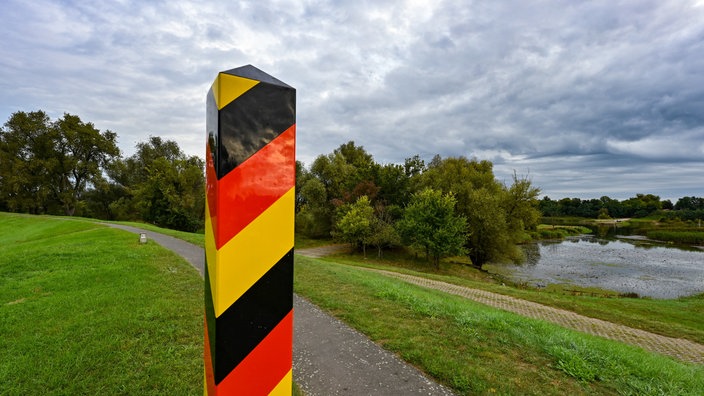 Ein Grenzpfeiler in den Nationalfarben Deutschlands steht auf dem Deich am deutsch-polnischen Grenzfluss Oder in der Ziltendorfer Niederung in Ostbrandenburg