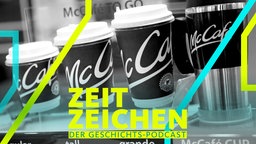 Diverse Kaffeebecher zum Mitnehmen stehen an einer McCafe-Verkaufstheke